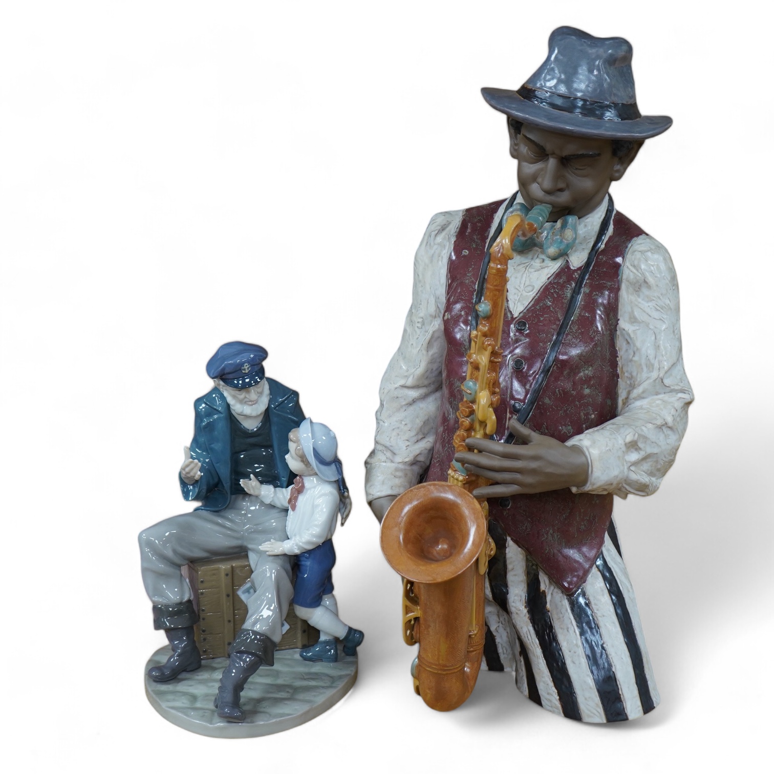 A Lladro figure ‘Playing the Blues’, 63cm high and a ‘Tall Yarn’ figure group of a fisherman and a boy. Condition - fisherman lacking the ship in his hand, otherwise good